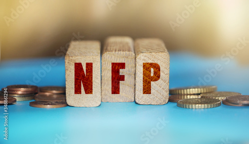 Wooden blocks with the word NFP. Nonfarm Payrolls - key economic indicator. Business concept photo