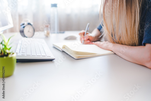 Young attractive girl leaning on office desk  working with a laptop at home