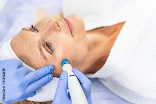 Procedure of microdermabrasion performed by a cosmetician photo