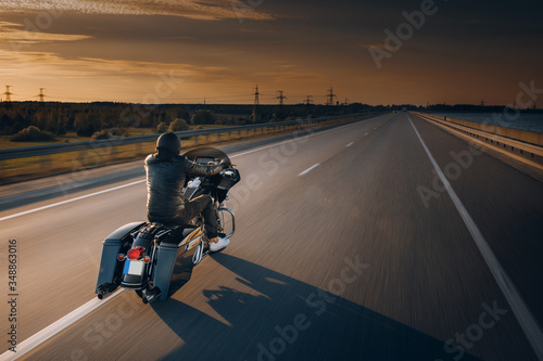 Fototapeta Motorcycle driver riding alone on asphalt motorway