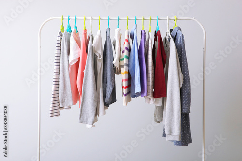 Children clothes on a rack on a light background. Children's clothing, children's stores. 