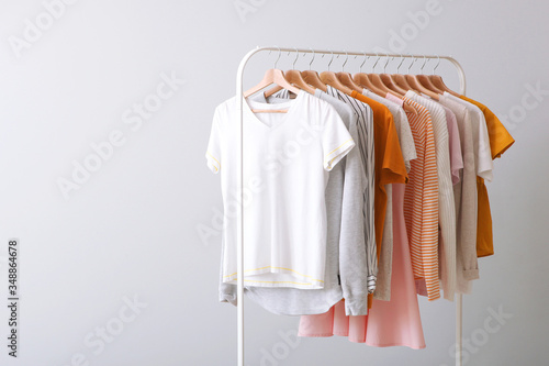 fashion clothes on a rack in a light background indoors. place for text photo