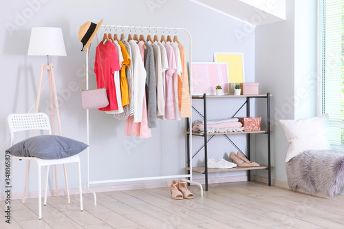fashionable clothes on a rack in a bright interior of the wardrobe room © White bear studio 