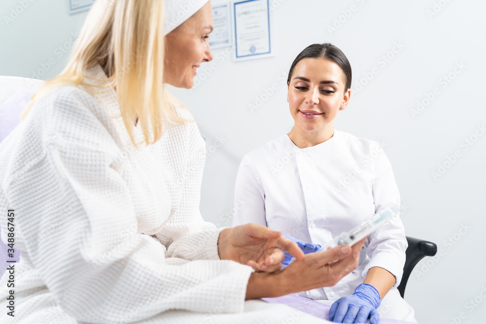 Obraz premium Dermatologist looking at a cosmetic product in her patients hand