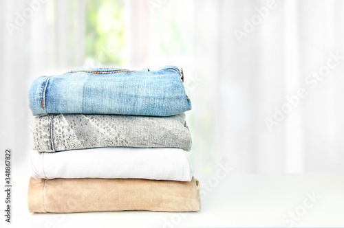 Stack different jeans table light background