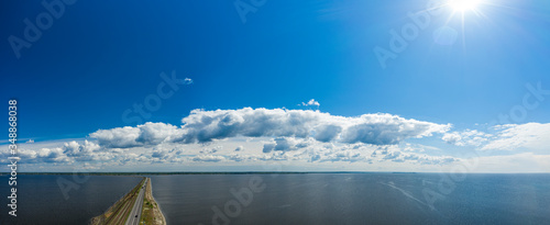 Aerial view of the amazing big river with dam under beautiful cloudy blue sky. Europe, Ukraine, Kremenchuk Reservoir, Dnieper or Dnipro River. Spring sunrise time. photo