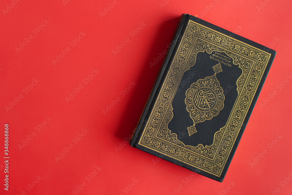 Quran on a plain burgundy background. Space for your text. Quran on a plain burgundy background. Space for your text.