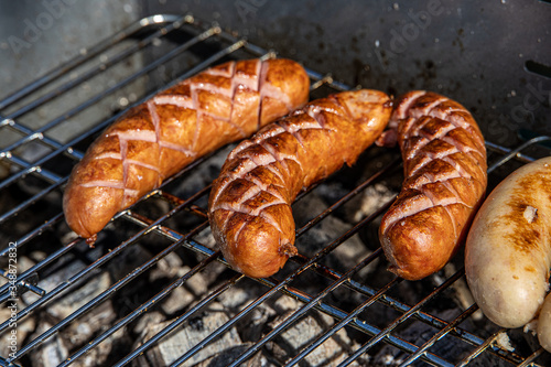 hot sausages lying on a hot grill close-up outside