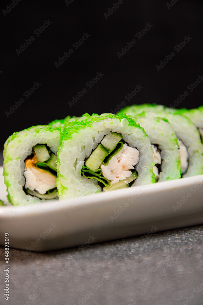 Rolls with green caviar, chicken and cucumbers. White glassware. Photo for the menu Rolls with green caviar, chicken and cucumbers. White glassware. Photo for the menu