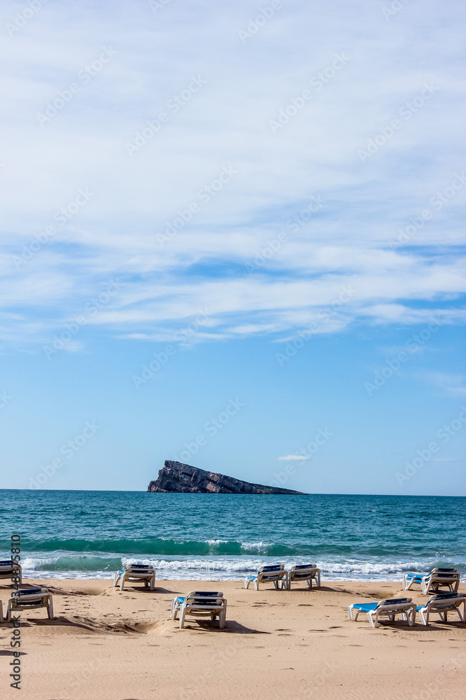 Obraz premium empty deck chairs by the sea, background with sea waves, sand and blue sky