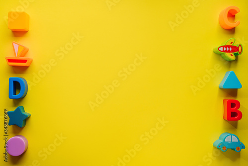 Top view on children s toys on a yellow background. Children's toys on the table. concept for advertising toys for children. Copy space children's toy.