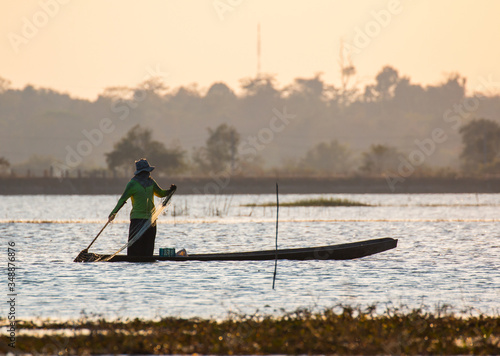  fisherman on canoe in tropical Bungva lake, Laos