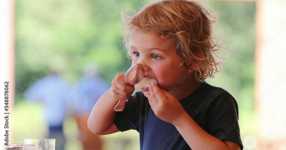 Child eating melong fruit dessert with spoon