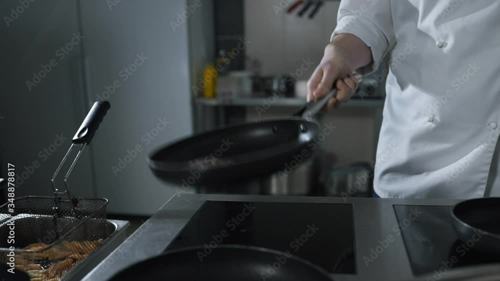 chef tosses roasting beef on the hot pan at the restaurant kitchen in slow motion chef tosses roasting beef on the hot pan at the restaurant kitchen in slow motion