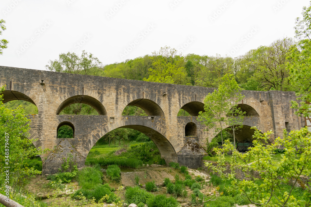 Fototapeta premium Tolle Ausblicke auf die Landschaft von Rothenburg ob der Tauber bieten sich bei einer Wanderung durch das Taubertal. Die Doppelbrücke ist ein imposantes historisches Bauwerk mit vielen Bögen. 