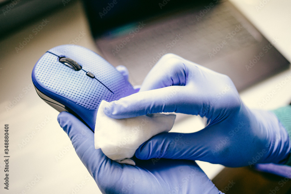 office sanitizing wipe wiping mouse and mousepad with disinfecting wipes. Coronavirus COVID19