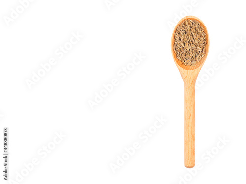 Spice cumin (jeera) in wooden spoon isolated on white