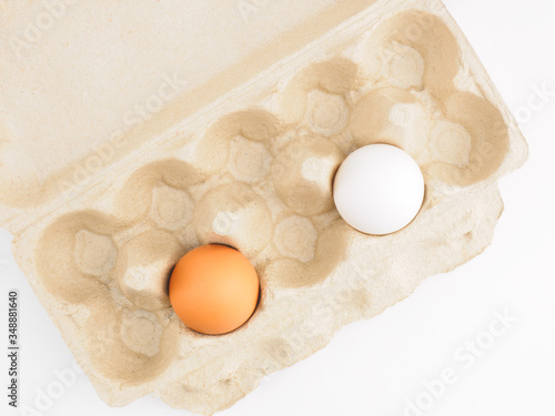 Fototapeta Naklejka Na Ścianę i Meble -  Two raw chicken eggs per pack on white background. Healthy eating and organic food concept