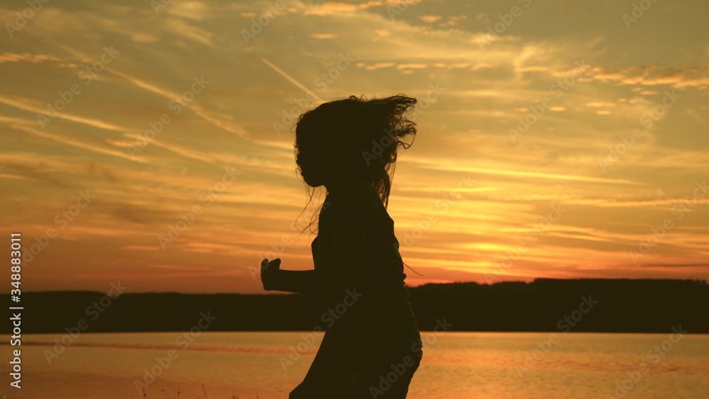 free girl dancing at sunset with long hair in rays of the sunset. healthy woman dancing at the beach party. Evening dancing on the seashore. Slow motion. girl traveller, tourist is dancing