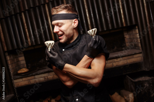 Cheerful chef posing with a serving of Khinkali. Georgian national traditional cuisine. Cooking process. Kitchen. Food concept