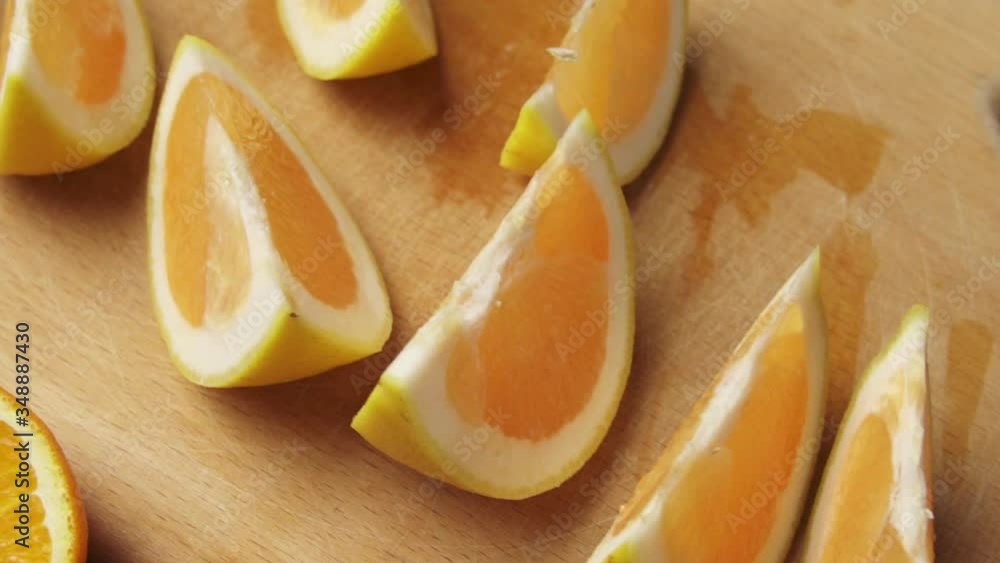 Fresh orange fruits on a wooden table, whole and sliced. A plate full of citrus slices. Fresh orange fruits on a wooden table, whole and sliced. A plate full of citrus slices.