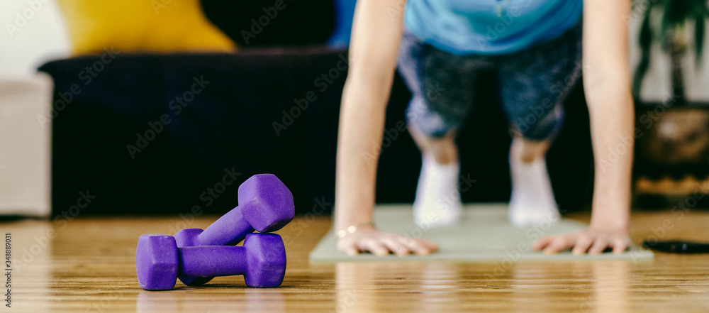woman doing exercise at home stay fit indoors focus on dumbells woman doing exercise at home stay fit indoors focus on dumbells