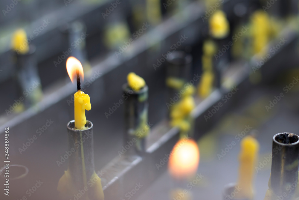 Yellow candles and flames on a candle holder.