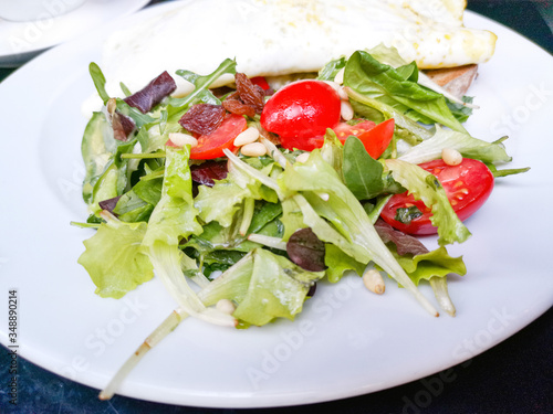 White omelet served with avocado slices on grilled bread toast with fresh lettuce and cherry tomatoes for side dishes ready to be eaten