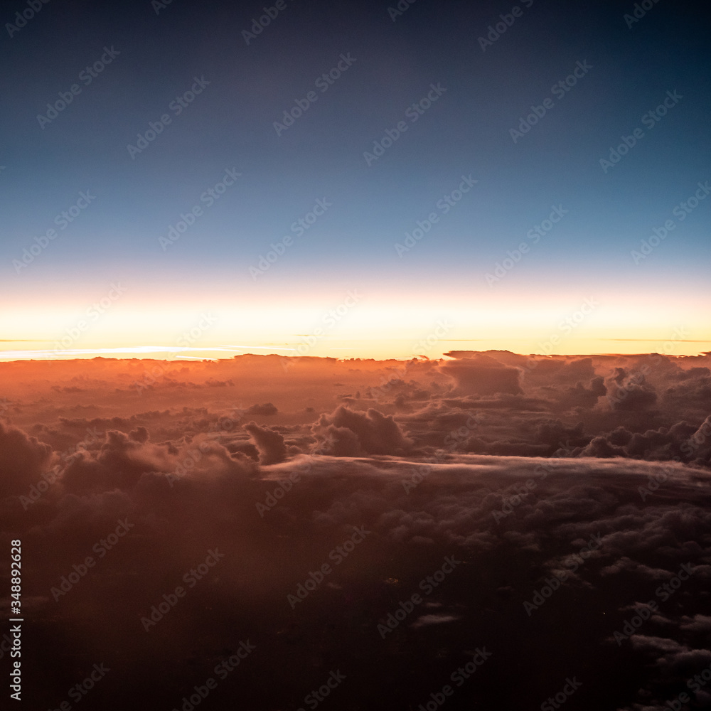 Sunset above the clouds. An aerial view above the clouds as the sun passes and night approaches.