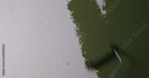 hand painting wall in green color with paint roller