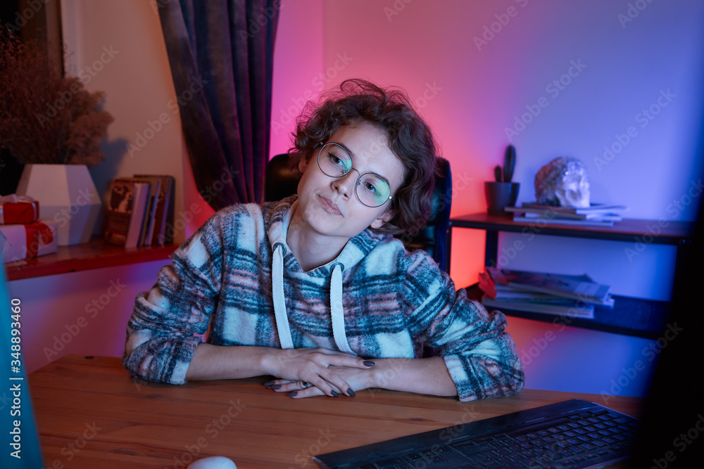 Young freelancer working from home sitting in a cosy chair at the desk with computer. Young freelancer working from home sitting in a cosy chair at the desk with computer.