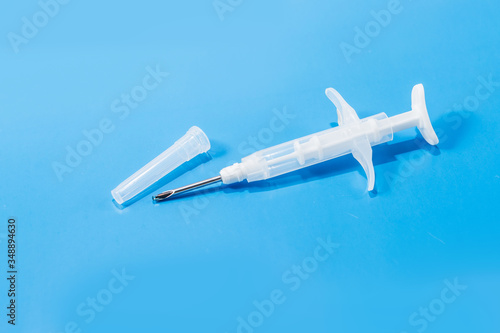 syringe with a microchip on a blue background, chipping, nobody, close up
