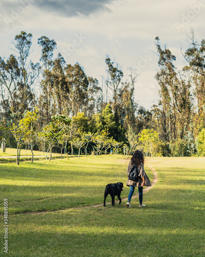 young woman walking with dog © Diego
