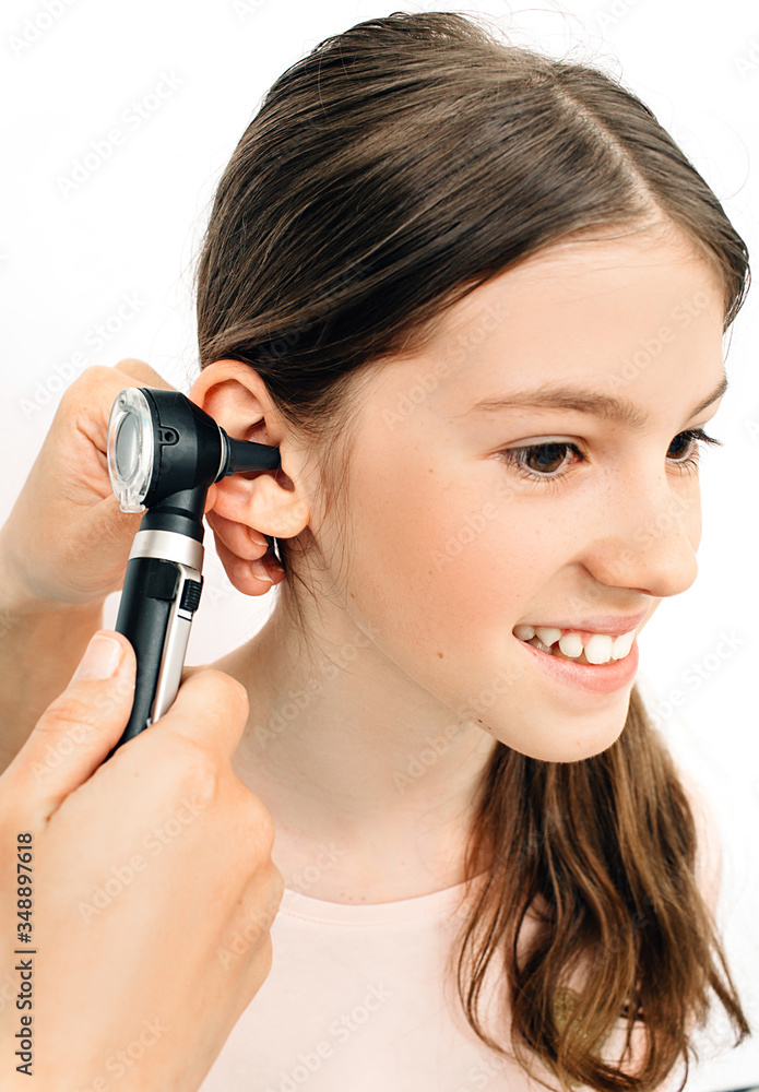 Child hearing exam. Diagnosis of impairment and hearing testing in children. Girl during an ear checkup with an audiologist Child hearing exam. Diagnosis of impairment and hearing testing in children. Girl during an ear checkup with an audiologist