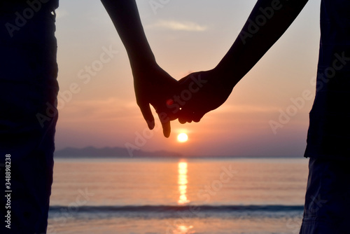 Silhouette Romantic Couple holding at sunset on the beach