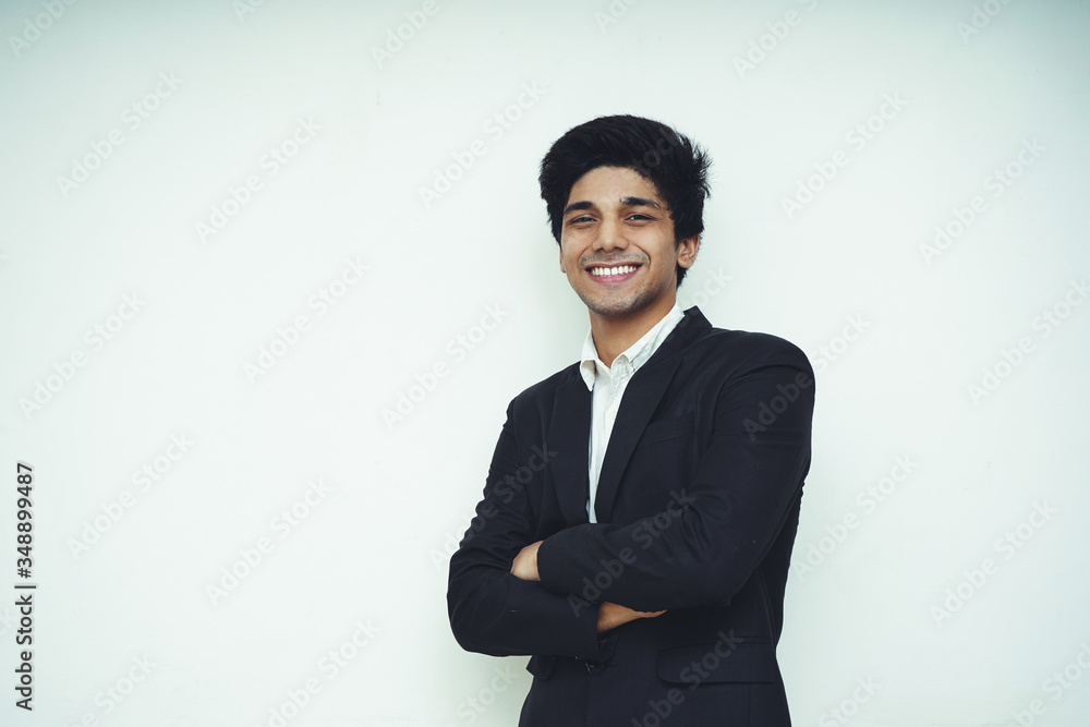 Portrait of a young handsome Asian confident Business man wearing black coat and standing on a white wall Portrait of a young handsome Asian confident Business man wearing black coat and standing on a white wall