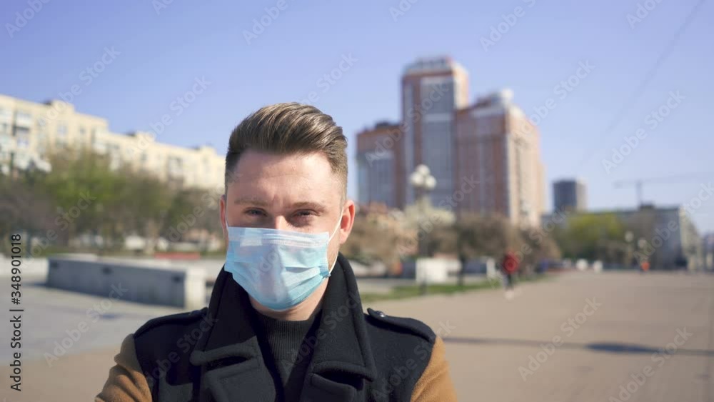 Caucasian man puts on medical mask on empty city street. Close up portrait Caucasian man puts on medical mask on empty city street. Close up portrait