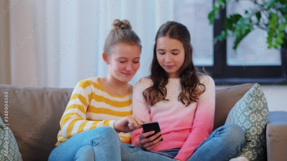 people, technology and friendship concept - happy teenage girls with tablet computer sitting on sofa at home people, technology and friendship concept - happy teenage girls with tablet computer sitting on sofa at home