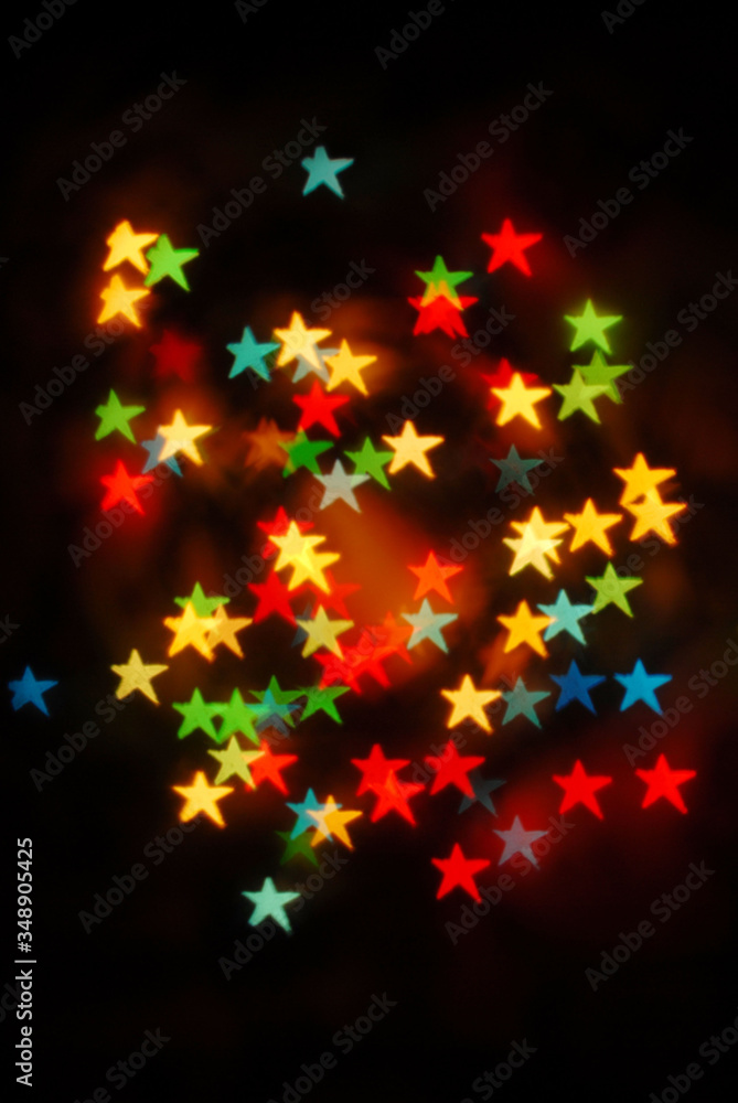 Bokeh stars colored lights on black background, Christmas