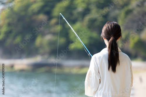 海辺で釣りを楽しむ若い女性 © west_photo