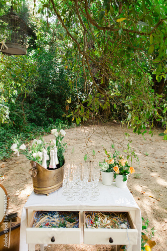 champagne and glasses on a rustic dresser for a boho wedding. 