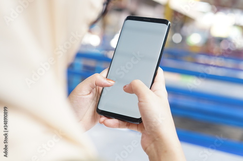 Woman hand holding black smartphone with blank screen for mock up. Cropped shot view of woman's hands holding a smartphone with blank copy space screen for your text message or information content.