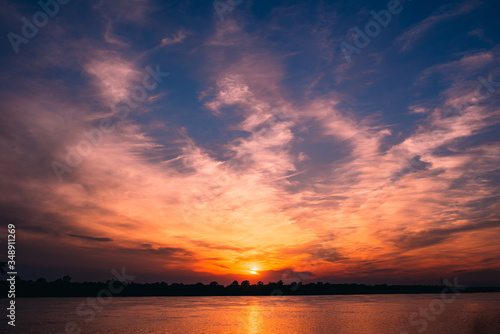 Orange sunset over the river © Julia