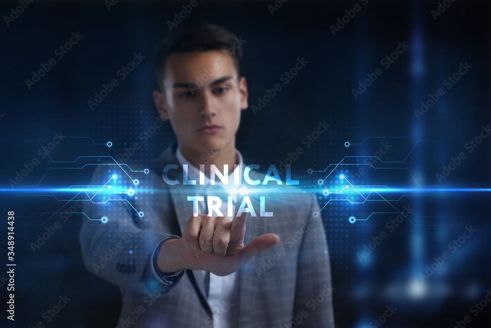 Business, Technology, Internet and network concept. Young businessman working on a virtual screen of the future and sees the inscription: Clinical trial Business, Technology, Internet and network concept. Young businessman working on a virtual screen of the future and sees the inscription: Clinical trial