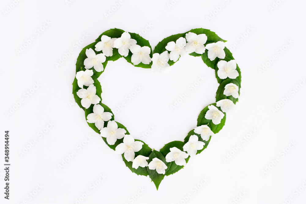 Flatlay in the shape of a heart from jasmine flowers on a white background.