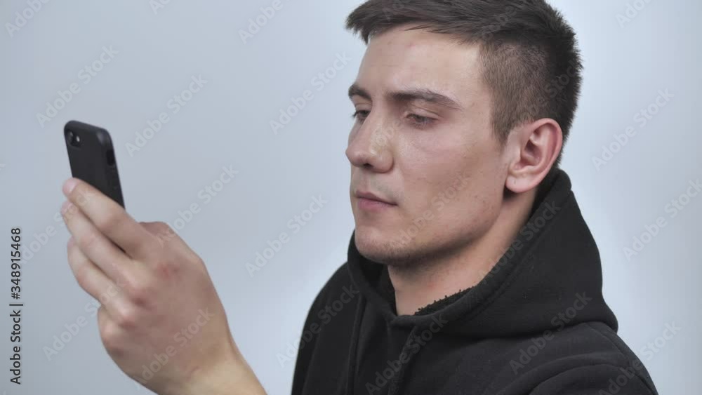 Closeup serious man search on the Internet mobile in studio 4k