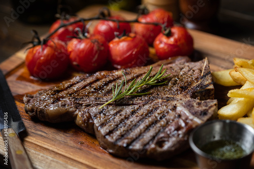 T-bone steak with baked tomato and french fries
