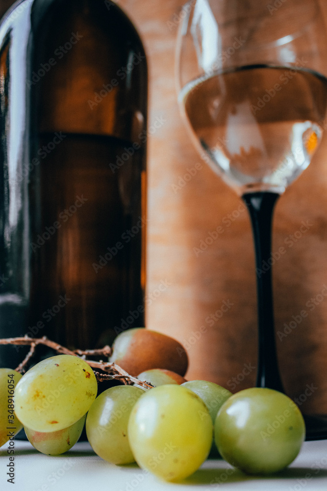 Bottle of wine, glass and grapes on a wooden background Bottle of wine, glass and grapes on a wooden background