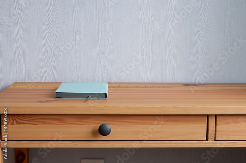 Notepad on a wooden table. Suitable for mockups and advertising backgrounds