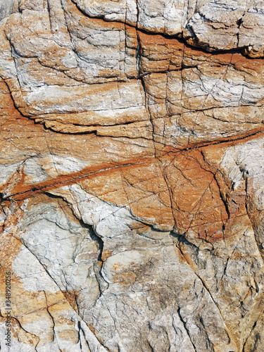 Background design texture of natural stone granite. multi-colored - red, gray.